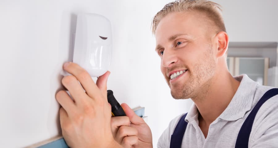 Man connecting a motion detector in a living area